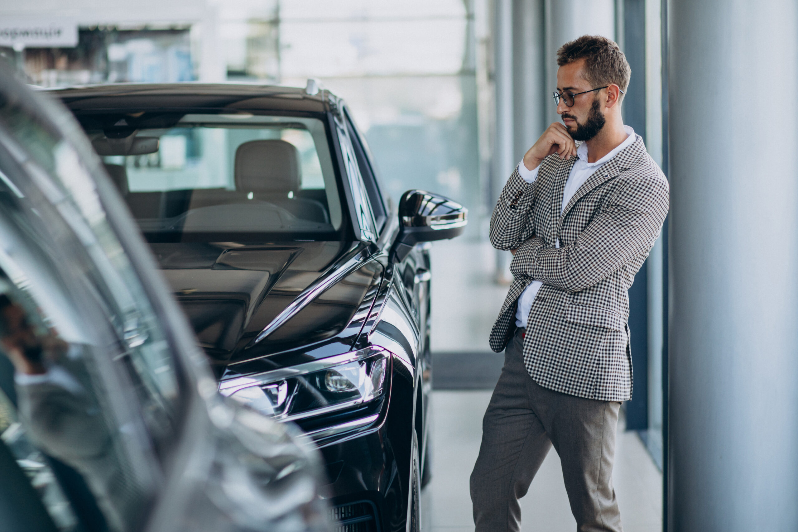 A businessman looks carefully at a low-maintenance luxury car.