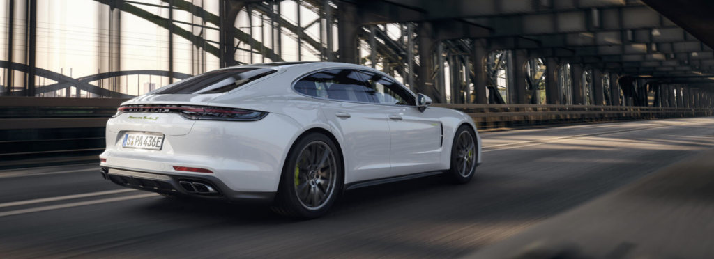 A sporty white Porsche Panamera is parked, and is the perfect luxury car for families.